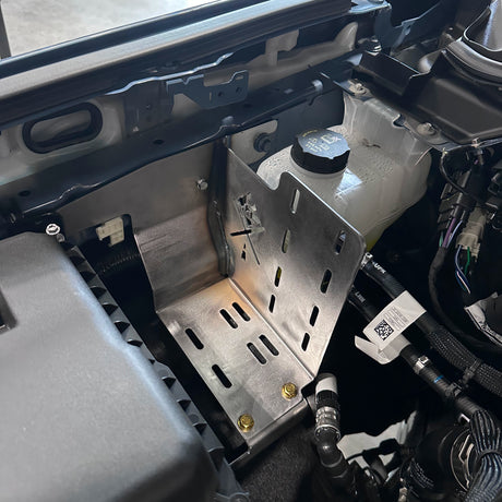 Close-up of a car's engine compartment with various components.