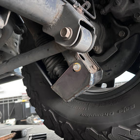 Close-up of a vehicle suspension system with a tire and wheel.