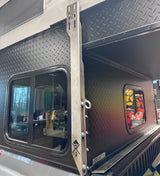 Metal awning bracket on black Project M camper