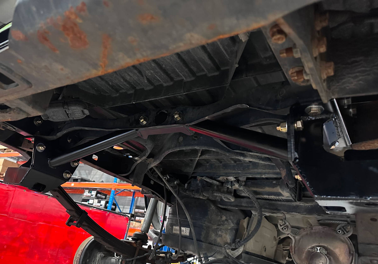 Close-up of a vehicle's undercarriage with visible rust and mechanical components.