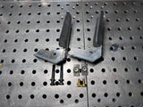 Metal brackets and screws on a perforated metal surface