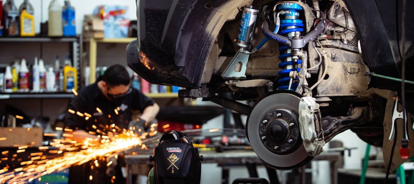 Car suspension system with a mechanic working in the background