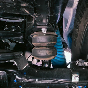Close-up of a vehicle's suspension system with a blue spring.
