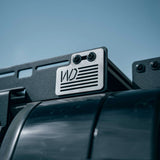 License plate holder with a logo on a vehicle against a blue sky