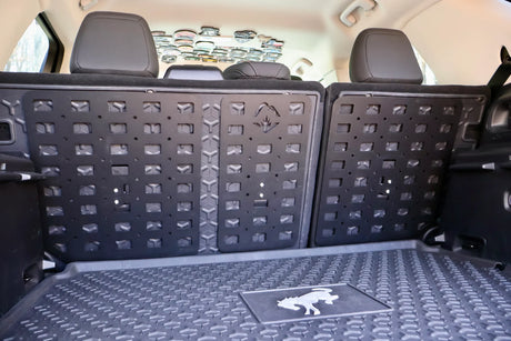 Car trunk with a black cargo liner and a gray mat.