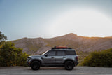 SUV parked on a road with mountains in the background