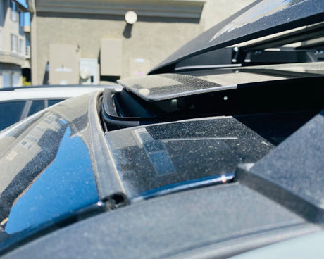 Close-up of a car's open sunroof with a building in the background