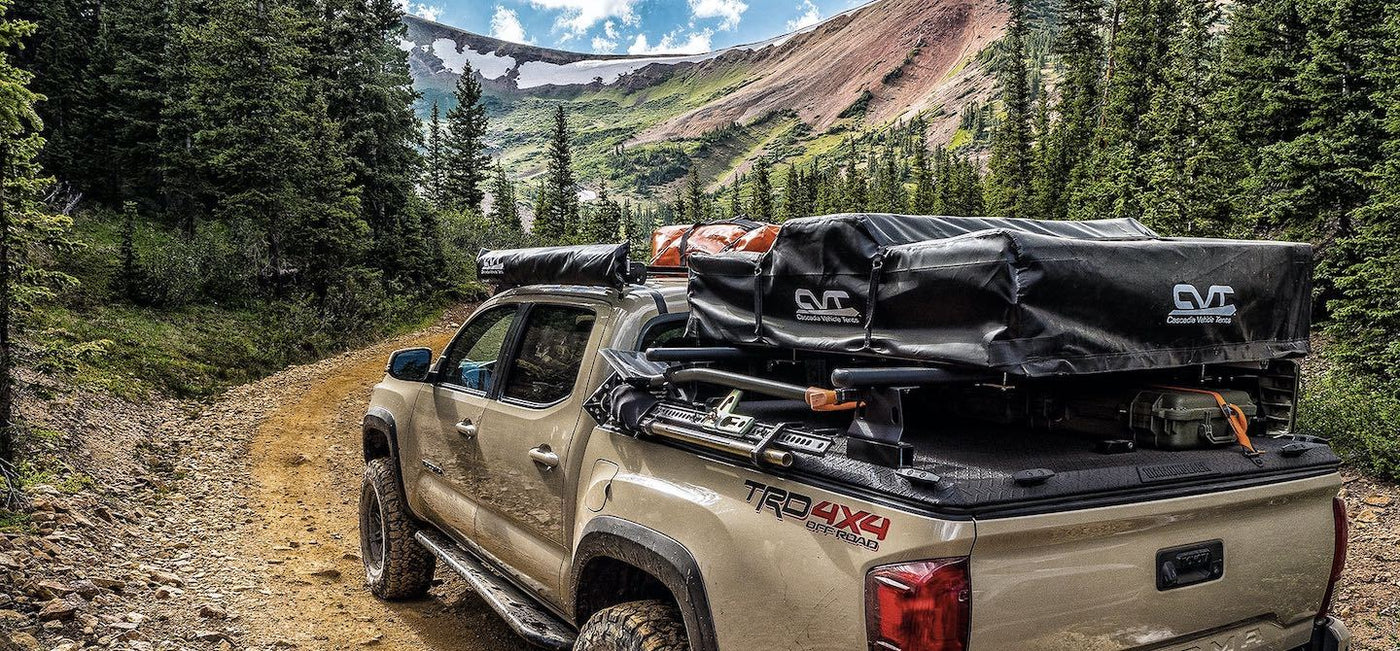 Beige Tacoma overlanding in Canada with a loaded up DiamondBack tonneau cover